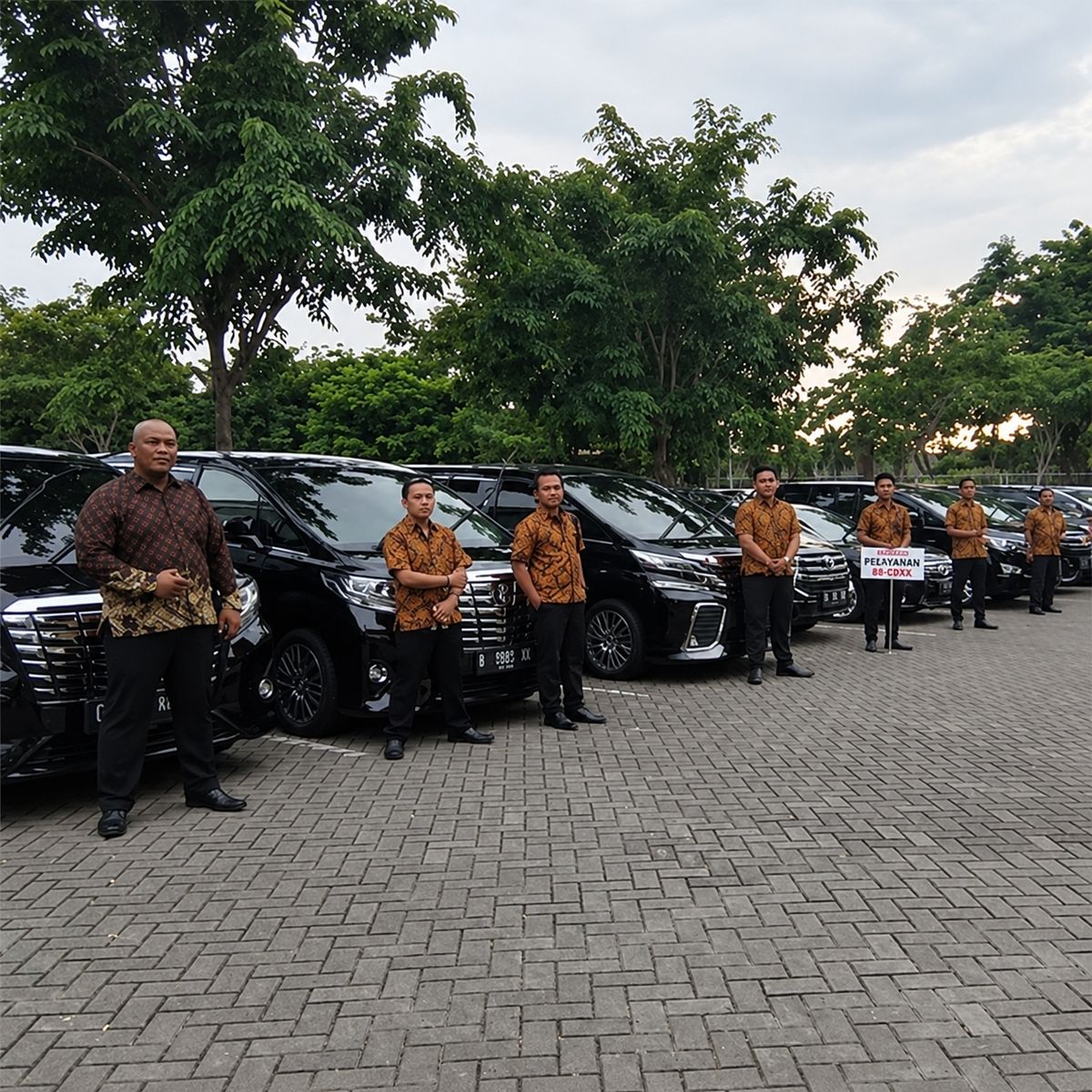 Tim driver berbaris di samping armada hitam